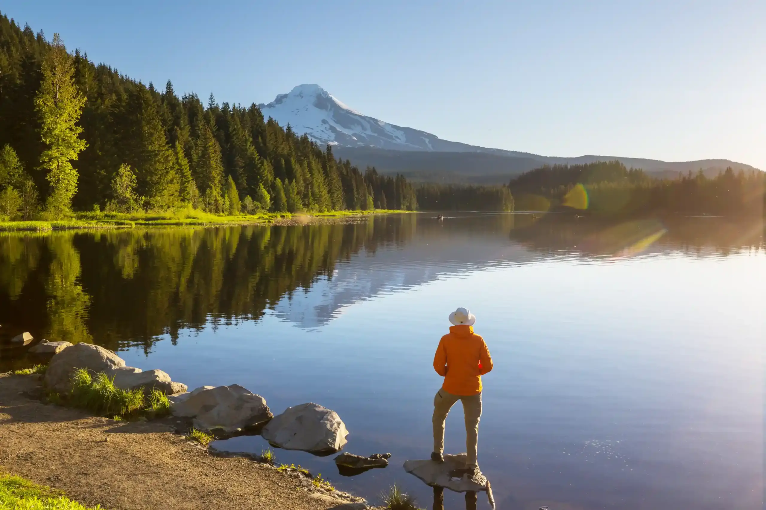Man standing on a rock at a gorgeous lake with Mountain View