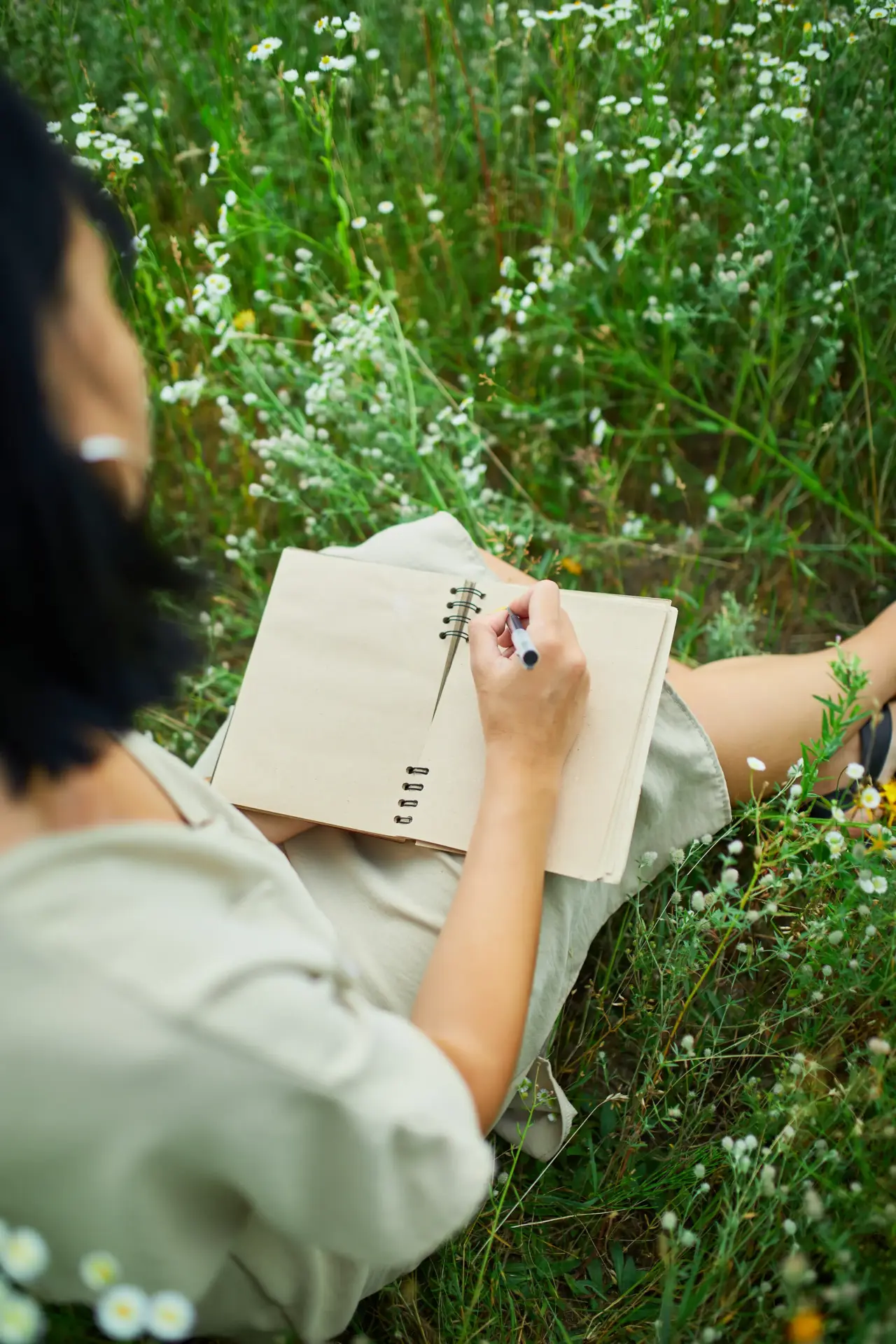 Vrouw in weiland met dagboek en pen